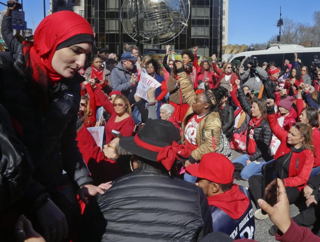 FILE - This March 8, 2017, file photo shows civil rights leader and activist Linda Sarsour, far left, during the International Women’s Day rally and sit-down protest outside Trump International Hotel at Columbus Circle, in New York. Conflicts over control, inclusivity and alleged anti-Semitism mean that women protesting on the second anniversary of the Women’s March on Washington will have competing demonstrations Saturday, Jan. 19, 2019, in New York City.