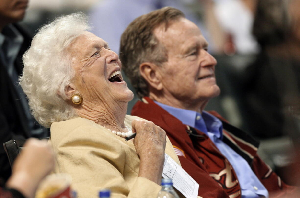 Barbara Bush laughs alongside former President George H.W. Bush as they attend a baseball game April 18, 2009, in Houston. Both Bushes died in 2018; she on April 17, he on Nov. 30.