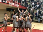 The Union boys basketball team lifts up Ethan Smith moments after an 82-68 win over Camas in which he hit a school-record eight 3-pointers on Friday night at Camas High School.