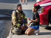 Clark County Fire District 6 firefighter Dominic Sepe comforts Olivia Calton, 15, as firefighters work to put out a fire at her home on the evening of July 30, 2018, in Vancouver. Columbian staff photographer Alisha Jucevic, who captured the moment, was recognized Friday with an Award of Excellence in the prestigious Pictures of the Year International photo contest.