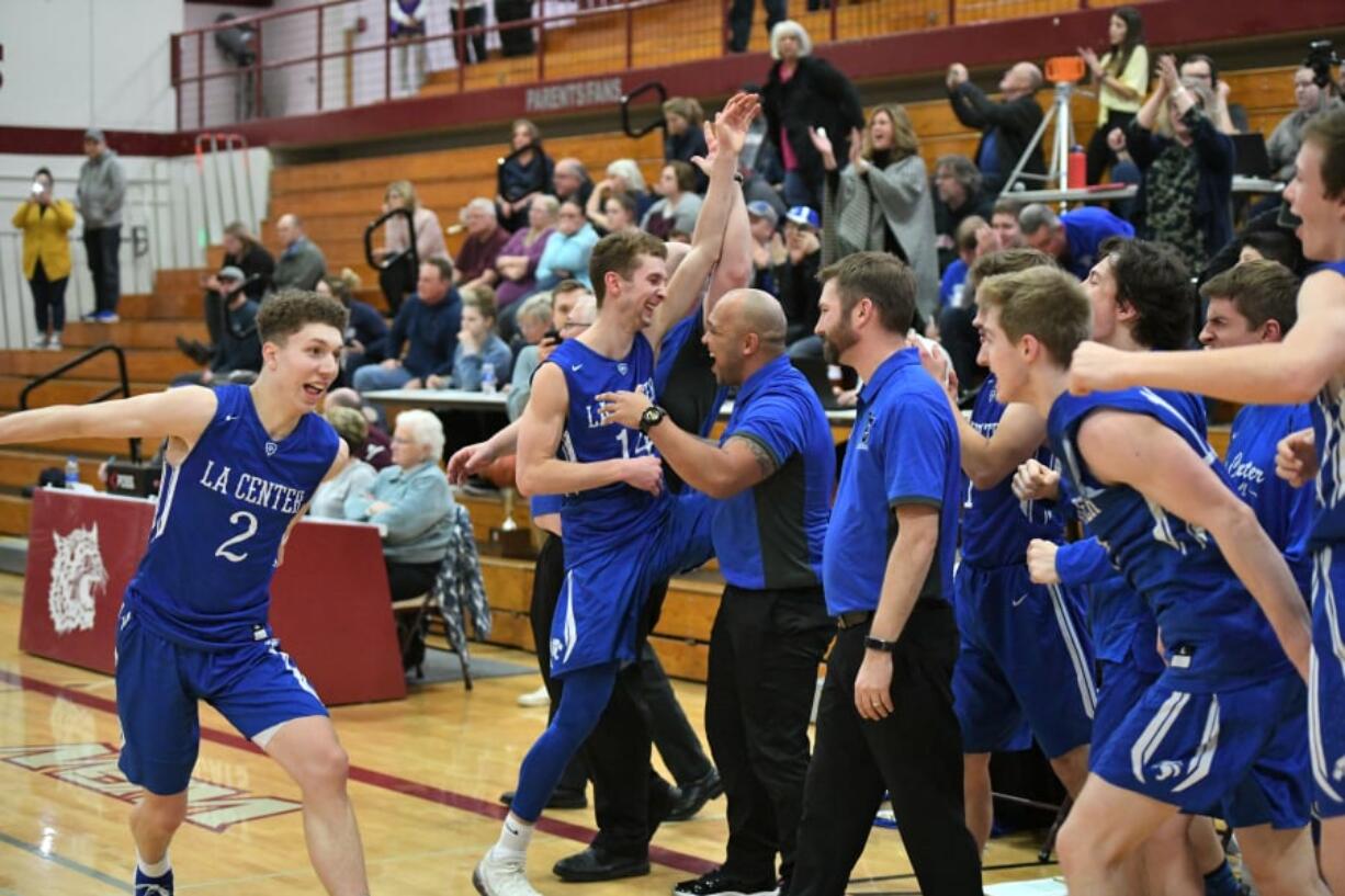 The La Center boys basketball team celebrate their district championship win over King’s Way Christian on Friday night at W.F. West High School.