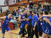 The La Center boys basketball team celebrate their district championship win over King’s Way Christian on Friday night at W.F. West High School.