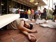 A student lays on the ground simulating injuries sustained in an earthquake as media follow members of USC’s Campus Emergency Response Team during a drill on October 15, 2015, in Los Angeles.