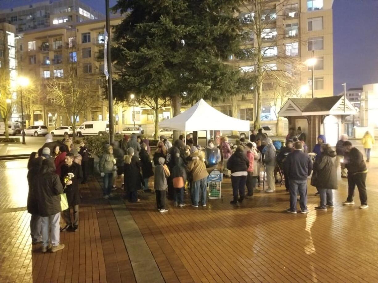 Attendees linger following a candlelight vigil on Saturday to honor Clayton Joseph, the 16-year-old who was shot and killed by Vancouver police on Tuesday. Following the half-hour vigil, some of the crowd broke into smaller groups and exchanged flowers.