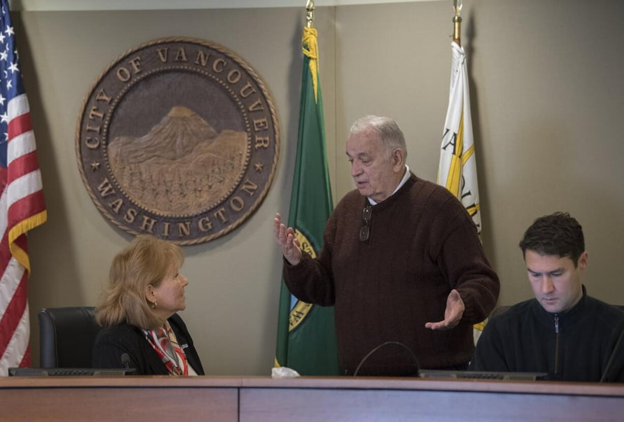 Bill Turlay, standing as he speaks with Vancouver Mayor Anne McEnerny-Ogle last year, says he will seek a third term on the Vancouver City Council. City Councilor Bart Hansen sits nearby.