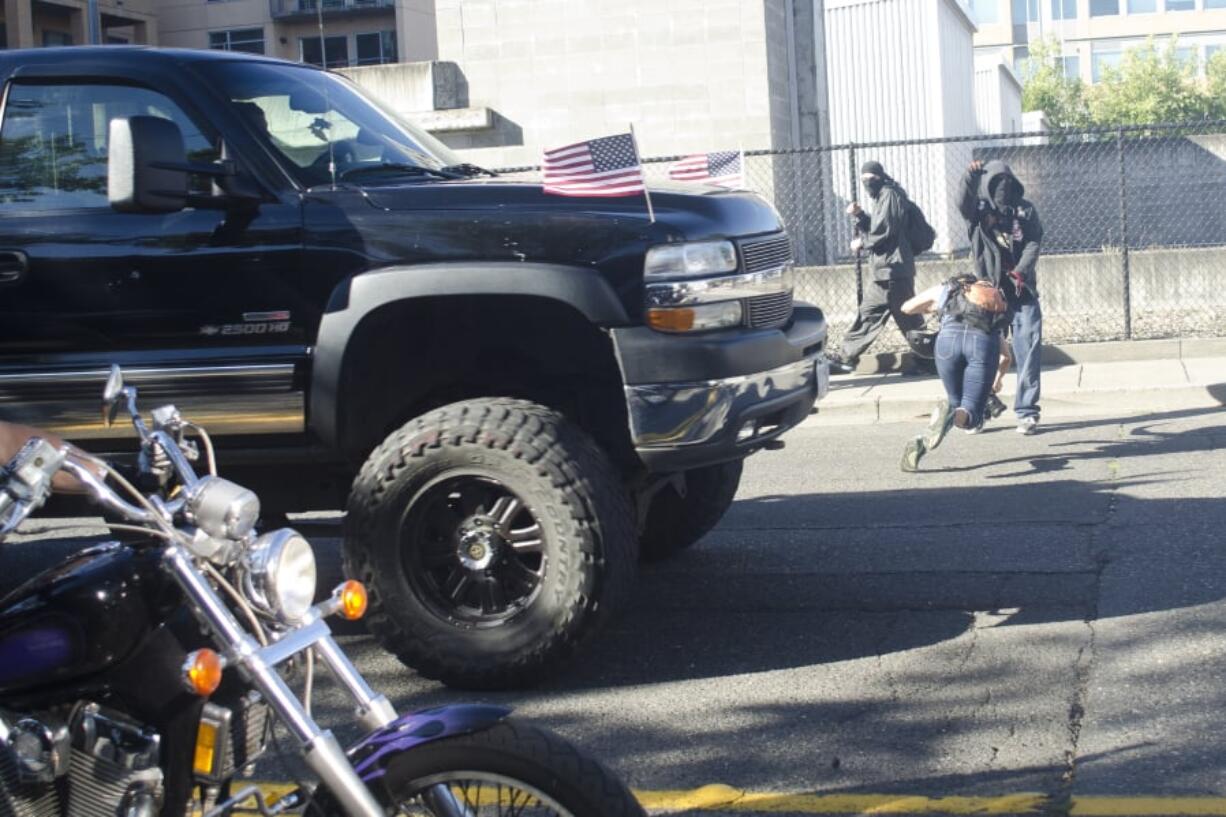 A photographer dives out of the way of a speeding truck after a rally held by Joey Gibson’s Patriot Prayer group in Vancouver on Sept. 10, 2017. The event had been moved to Vancouver from Portland in an attempt to avoid protesters.