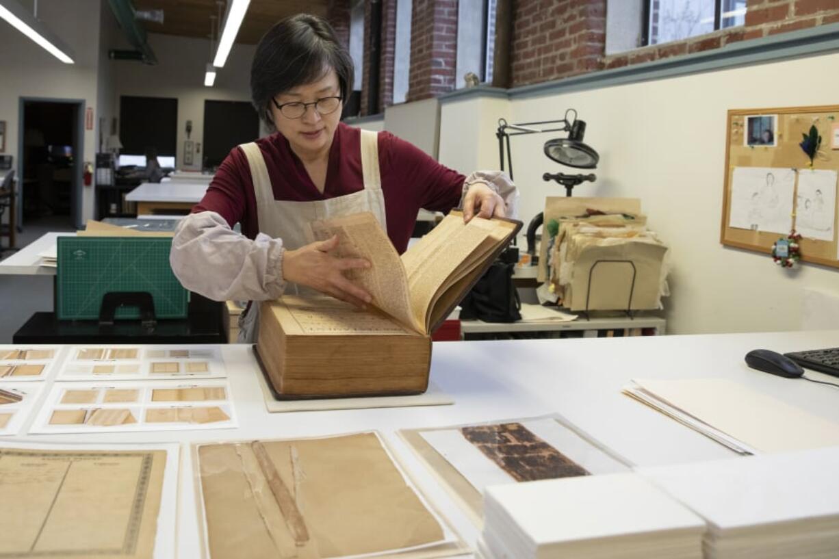 Jungohk (Theresa) Cho, who restored Betsy Ross’s family Bible, flips through its pages Feb. 12 in the lab at the Conservation Center for Arts and Historic Artifacts in the Rittenhouse neighborhood of Philadelphia.