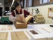 Jungohk (Theresa) Cho, who restored Betsy Ross’s family Bible, flips through its pages Feb. 12 in the lab at the Conservation Center for Arts and Historic Artifacts in the Rittenhouse neighborhood of Philadelphia.