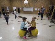Mount Pleasant School District third-grader Ari Syulyukov, 8, left, and second-grader Zoey Duff, 7, play during recess in the school’s aging gym.