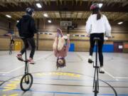 To top off their show with a special surprise, Pleasant Valley Middle School eighth-graders Bryce Phillips, left, and Madison Clouse, right, pedal giraffe unicycles while sixth-grader Piper Crain executes a moving front flip.