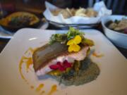 Ora king salmon, foreground, with queso fundido. Background from left: chips and crispy bruselas.