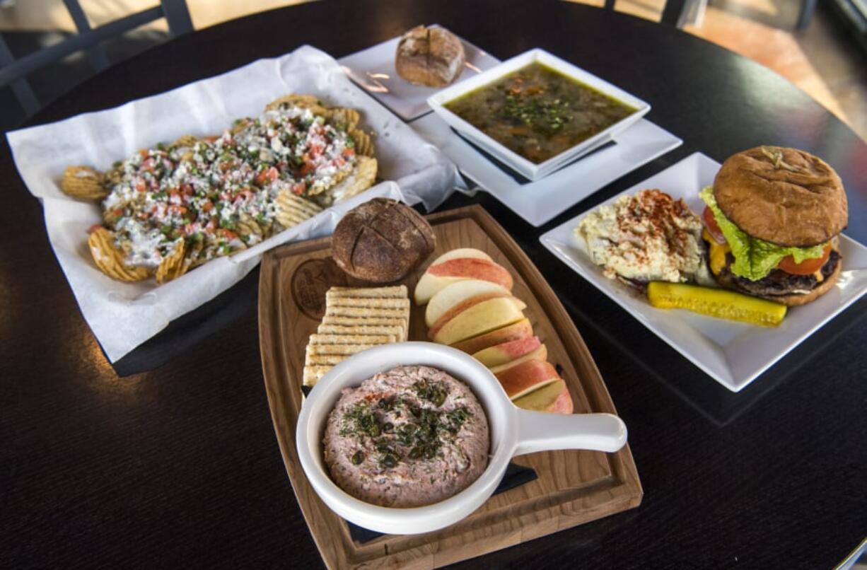 The salmon dip, clockwise from front, the Bleu Dirties, chicken and veggie wild rice soup, and the bison bacon and cheddar burger are pictured at Ben’s Bottle Shop.