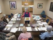 Nathan Howard/The Columbian Becky Leventis shows a painting to seniors at The Quarry Senior Living. Leventis teaches monthly art classes at The Quarry, its sister facility Glenwood Place Senior Living, and less often at Prestige Senior Living Bridgewood.