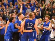 The La Center boys basketball team celebrates after beating King’s Way Christian in overtime Friday to capture the Trico League championship.