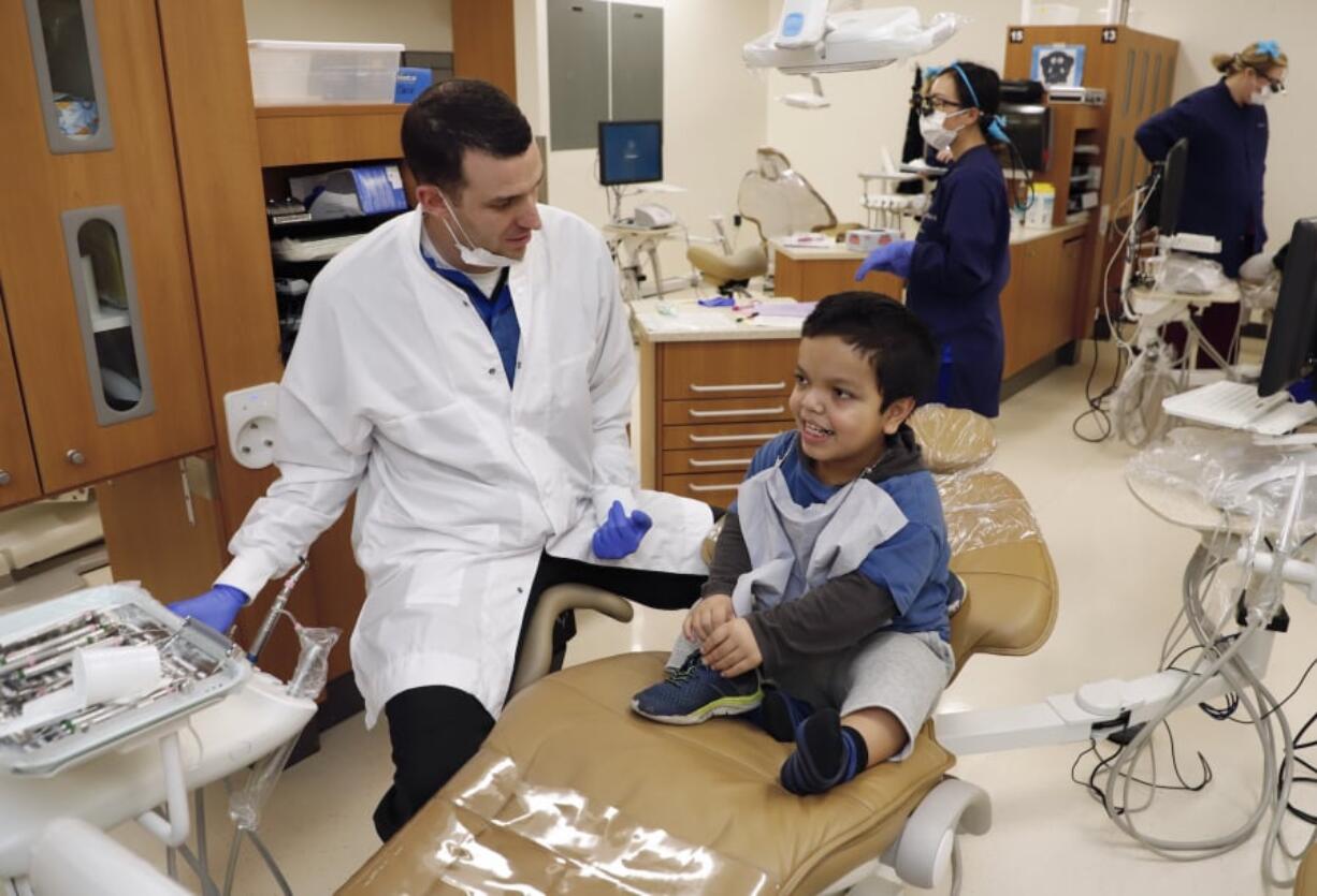 Dr. Joseph Kelly, left, chats with 9 year-old Samuel Pena, right, at a free children’s dental clinic held Saturday at Clark College.