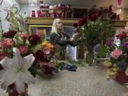 Florist Jane BonVillain arranges a vase of red roses at Ridgefield Floral & Gifts. Though Ridgefield is her hometown, she began her floral career working in a shop in Manhattan and returned to Clark County to be closer to her mother.