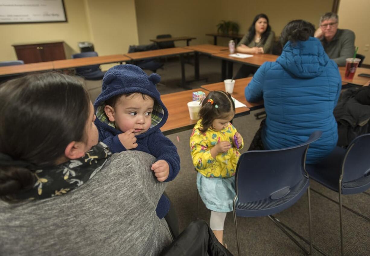 Above, Irene Cruz of Vancouver, from left, holds her baby, Nathan Pina, 1, while attending an education and support class for Spanish-speaking families who have children with developmental disabilities. The group began meeting in December.