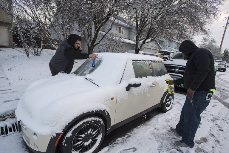 Cesar Cazares, left, and Otto Valdez, both of Vancouver, battle the elements in Cascade Park while heading out for work after snow blanketed the area Tuesday morning, Feb. 5, 2019.