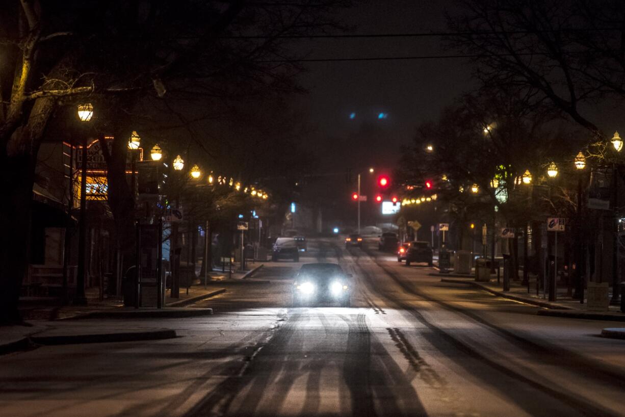 A motorist travels along an snowy Main Street in Vancouver on Monday night, Feb. 4, 2019.