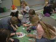 Cape Horn-Skye Elementary School students Wyatt Taylor, from left. Alyssa Jackson, Amelia Volosenco, Claire Taylor work on knight-themed crafts during a Battle of the Books tournament.