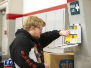 Andrew Brands checks a first-aid kit while working on campus. Brands puts some of his earnings into an ABLE account, a savings plan designed for people with disabilities.