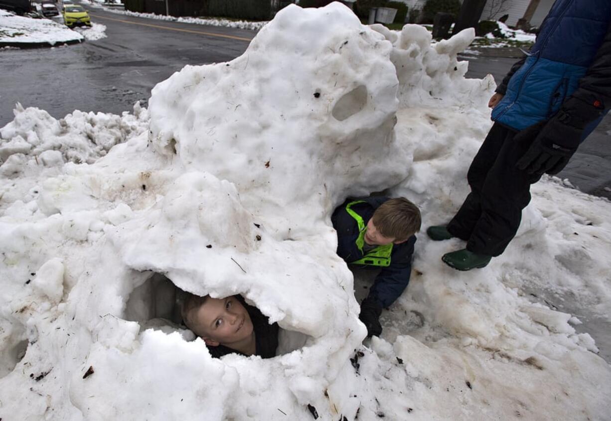 Levi Kellar, 7, of Washougal peers out of a snow fort he helped build with his brothers, Ben, 11, and Sam, 9. The brothers took advantage of a snow day to make the most of the remaining snow on the ground, which was beginning to melt because of rainy conditions.