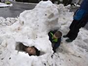 Levi Kellar, 7, of Washougal peers out of a snow fort he helped build with his brothers, Ben, 11, and Sam, 9. The brothers took advantage of a snow day to make the most of the remaining snow on the ground, which was beginning to melt because of rainy conditions.