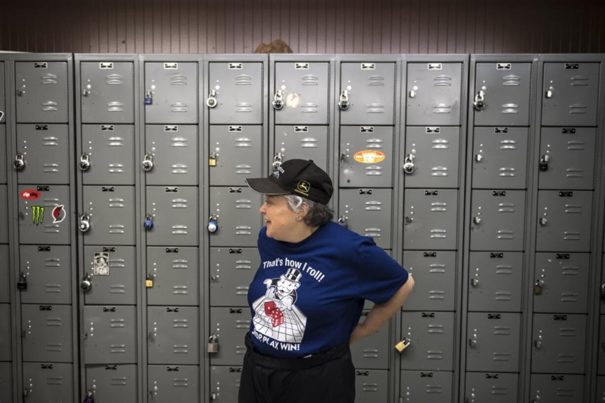 Tammi Graves gets ready for work in the Salmon Creek Albertsons break room. Graves, 45, of Ridgefield has struggled with reading comprehension her entire life and gets support through Trillium Employment Services, a nonprofit that receives funding from the Clark County Developmental Disabilities program.