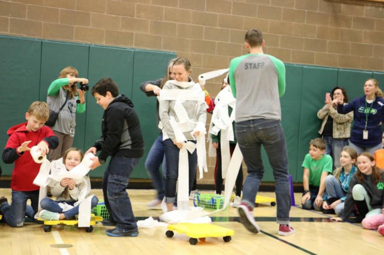 Battle Ground: Tukes Valley Middle School students race to see who can wrap their classmates up as snowmen the fastest during an assembly to celebrate the school’s successful donation drive in support of the district’s Family and Community Resource Center.