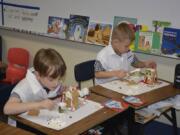 Washougal: Gause Elementary School first-graders Johnny Bradley, left, and Hudson Weaver build gingerbread houses for a lesson on the scientific method.