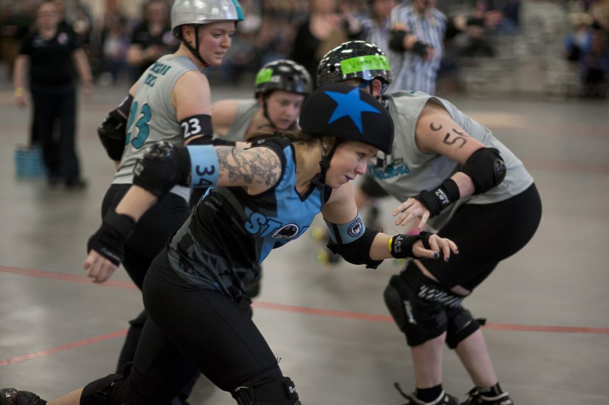 Exhibition match between Vancouver's Storm City Roller Girls (in black) and Portland's Rose City Roller Wreckers (in gray) at the Clark County Event Center at the Fairgrounds in Ridgefield. Trinity (in front) skates past the defense to score points.