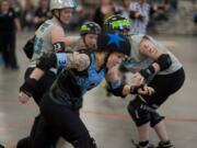 Exhibition match between Vancouver's Storm City Roller Girls (in black) and Portland's Rose City Roller Wreckers (in gray) at the Clark County Event Center at the Fairgrounds in Ridgefield. Trinity (in front) skates past the defense to score points.