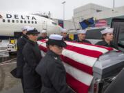 A military honor guard moves the body of Francis Dick from a Delta Airlines plane into a hearse while moving the casket from Portland International Airport to the Vancouver Funeral Chapel on Saturday, Feb. 9, 2019.