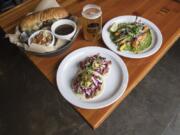 The Smoked Brisket Dip Sandwich with Potato Salad, from top left, Skyjacker IPA, Market Salad, and Veggie Tacos, front center, are seen here is seen here at Victor-23 Brewing on Friday, Feb. 15, 2019.