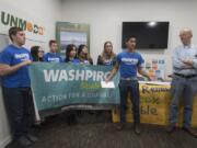 University of Washington sophomore Ishaan Bhimani, 19, second from right, joins fellow Washington college students as they speak out in favor of stronger renewable energy policy, while joined by Port of Vancouver Commissioner Don Orange, right, Monday afternoon. The group gathered at the offices of SunModo, a Vancouver solar panel-mounting company. Orange said he was not representing the Port of Vancouver at the event.