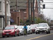 A cyclist bikes down Columbia Street toward Mill Plain Boulevard in Vancouver on Tuesday. The city is considering a proposal to replace the parking on Columbia Street with protected bike lanes, and the Clark County Veterans Assistance Center is concerned that this will affect accessibility for veterans, especially those with disabilities.