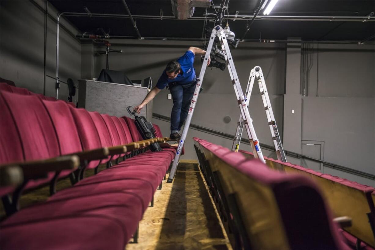 Sean Forsythe, system sales manager with Hollywood Lights, installs “Bill Roberts,” a LED light named for a “supervolunteer” at Magenta Theater last week.