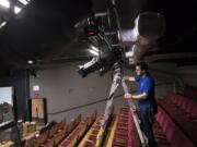 Sean Forsythe, system sales manager with Hollywood Lights, installs the news LED lights at Magenta Theater. The lights were bought with match grant from the Murdock Charitable Trust.