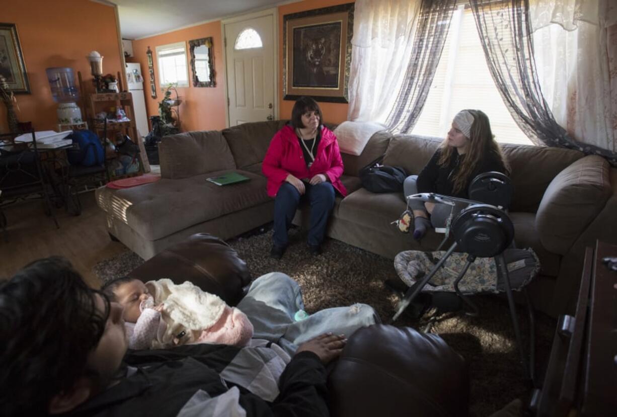 Kevin Garcia of Ridgefield holds his daughter, Lela Garcia, 6 weeks, as registered nurse Anne Johnston makes a home visit while joined by his girlfriend, Lisa Steele, who is Lela’s mom. Anne Johnston helps the parents navigate raising a child through Clark County Public Health’s Nurse-Family Partnership, but its nurses have been called to help with the measles outbreak response.