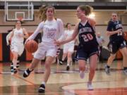 Prairie's Cassidy Gardner (15) attempts to dribble past Arlington's Sierra Scheppele (20) during the first half of a 3A regional basketball game at Battle Ground High School, Saturday, Feb. 23, 2019. Prairie went on to defeat Arlington 55-46.