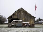 A dusting of snow rests on an old barn and car along NW 41st Avenue in Vancouver on Feb. 25, 2019.