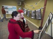 Krista Bashaw, red sweater, Camas Parks and Recreation special events coordinator, looks over photos and information about the Crown Park pool with former lifeguard Beverly Seagraves as they celebrate the history of the pool, which opened in 1954 and closed in 2017.