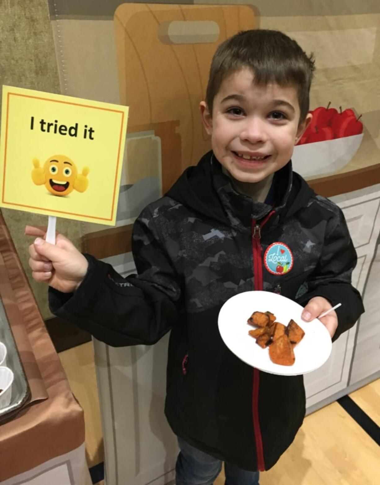 Five Corners: Sunset Elementary School student Brandon Martin with some of the sweet potatoes from the most recent Harvest of the Month at Evergreen Public Schools.