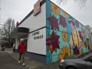 Cole Wyckoff of Vancouver strolls past Luepke Flowers and Finds on Wednesday afternoon. The business closed today. The Luepke Florist building, which was built in 1937, was added to the National Register of Historic Places in 2016.