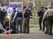 A Vancouver Fire Department paramedic checks for life signs on a man who was shot by police at the corner of West 12th Street and Jefferson Street in downtown Vancouver on Thursday afternoon.