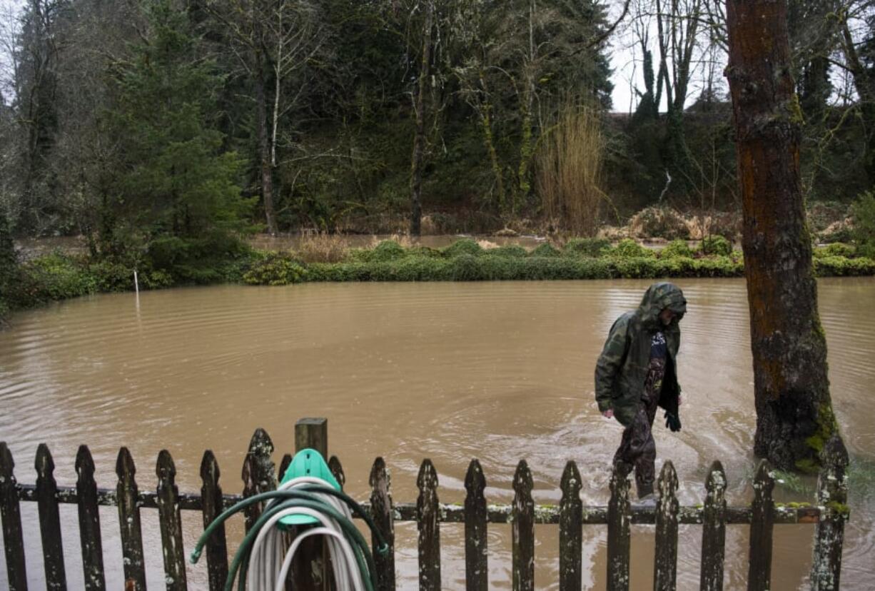 Joel Natterstad of Ridgefield wades through the flooded yard in front of the caretaker house at Abrams Park in Ridgefield. Natterstad volunteered to help the Public Works employees move sandbags throughout the morning and early afternoon.