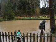 Joel Natterstad of Ridgefield wades through the flooded yard in front of the caretaker house at Abrams Park in Ridgefield. Natterstad volunteered to help the Public Works employees move sandbags throughout the morning and early afternoon.