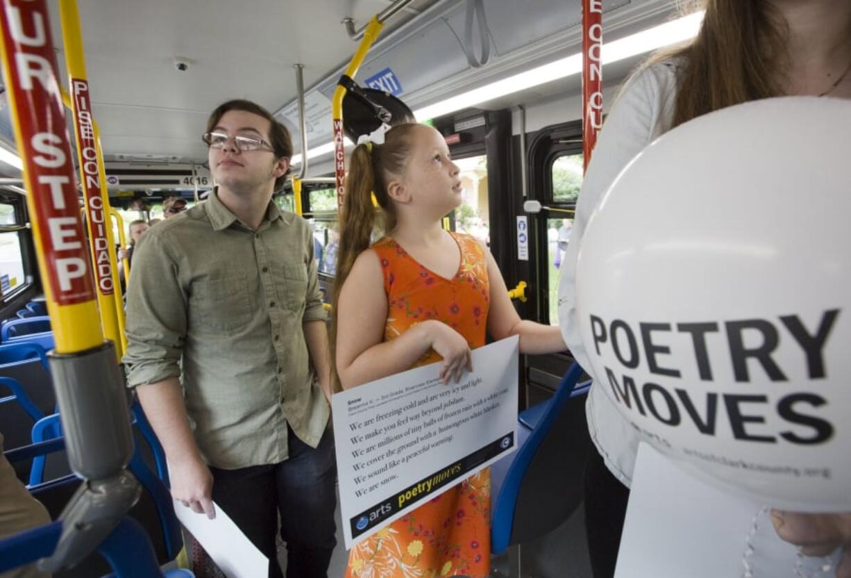 Poets on wheels: In this photo from summer 2016, ninth-grade poet Cole Beckwith of Fort Vancouver High School (left) and third-grade poet Breanna Kelley of Riverview Elementary School celebrate literature on a C-Tran bus.