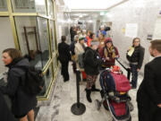 People line up in a hallway, Friday, Feb. 8, 2019, before a public hearing before the House Health Care &amp; Wellness Committee at the Capitol in Olympia, Wash. Amid a measles outbreak that has sickened people in Washington state and Oregon, lawmakers heard public testimony on a bill that would remove parents' ability to claim a philosophical exemption to opt their school-age children out of the combined measles, mumps and rubella vaccine. (AP Photo/Ted S.