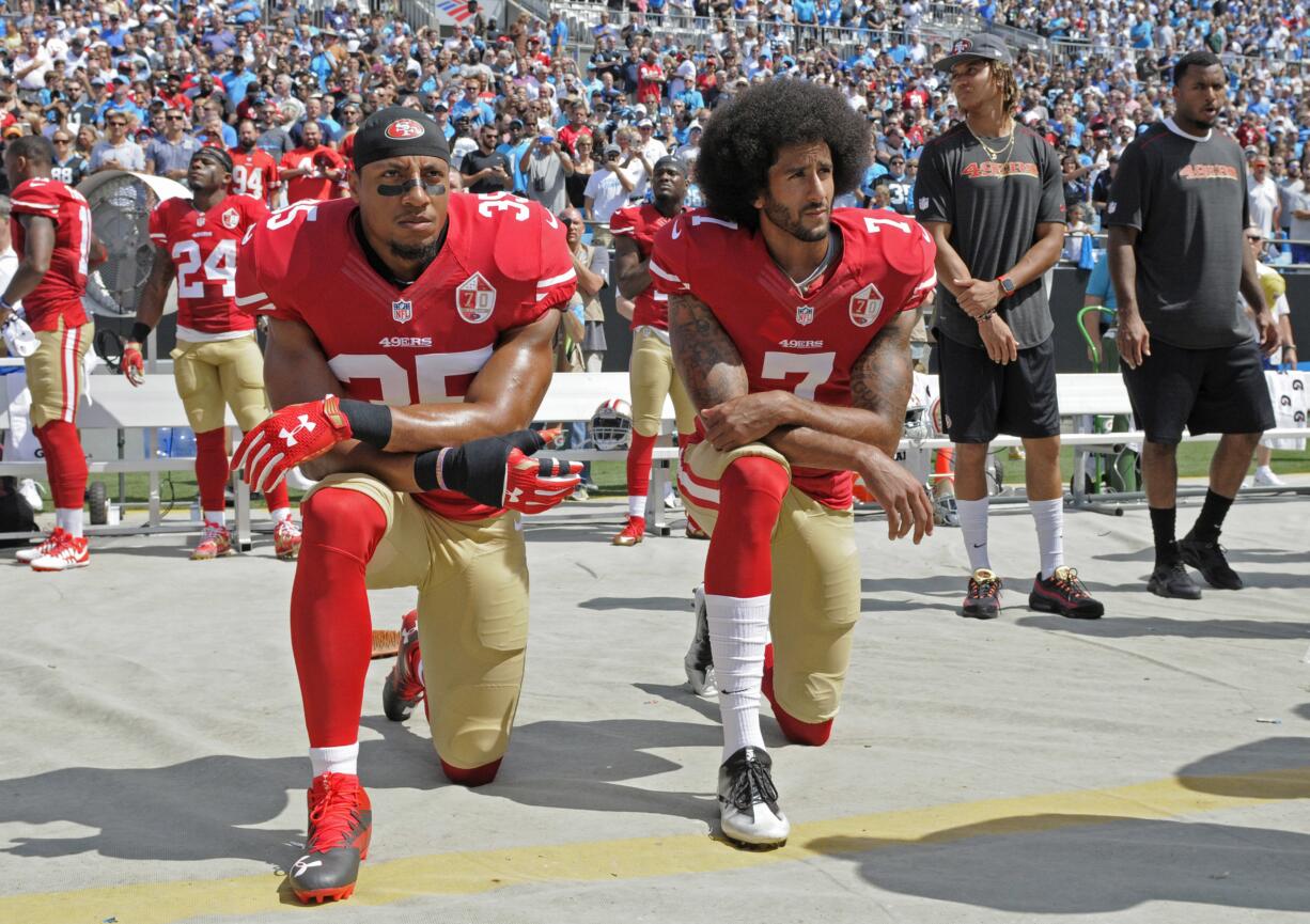 Colin Kaepernick (7) and Eric Reid (35) kneel during the national anthem before an NFL game in 2016. Kaepernick and Reid have reached settlements on their collusion lawsuits against the NFL, the league said Friday, Feb. 19, 2019.